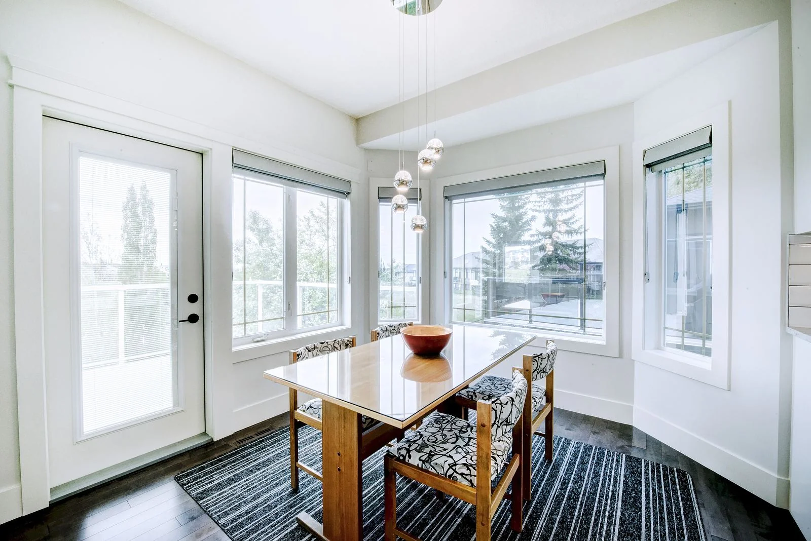 Dining table beside garden doors and a run of windows