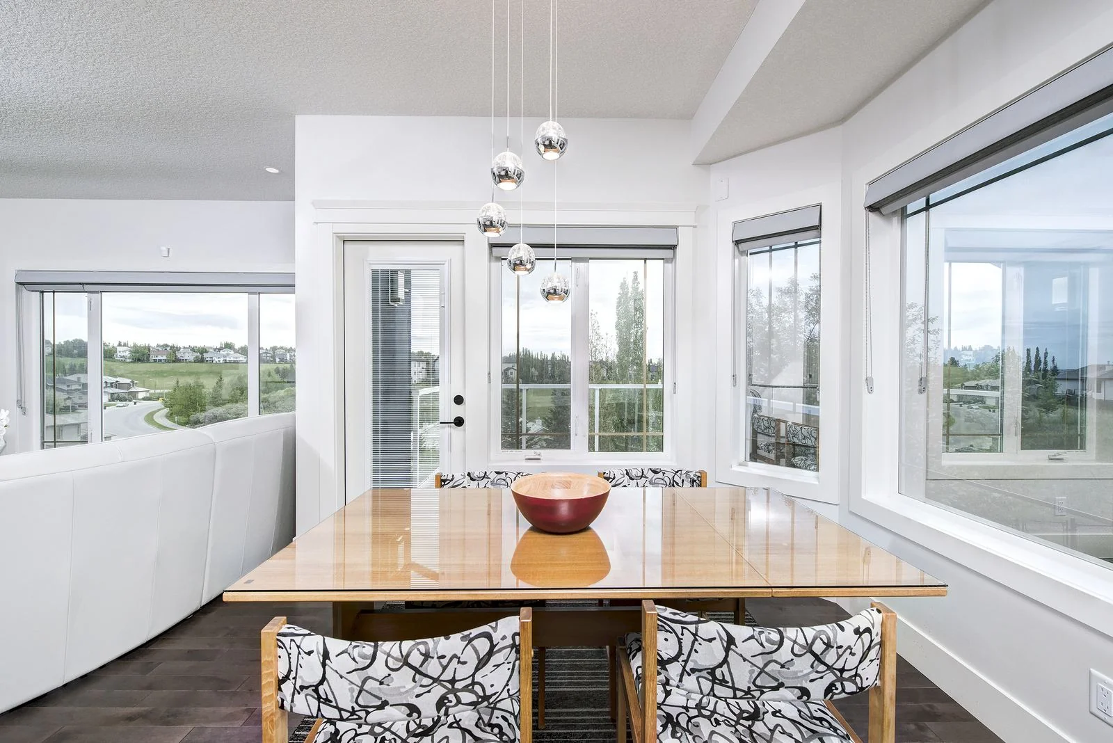 Dining area under pendant lights with corner windows