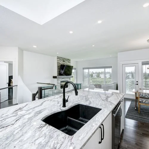 Arbour Lake, Calgary. Kitchen island and sink with the dining area beyond