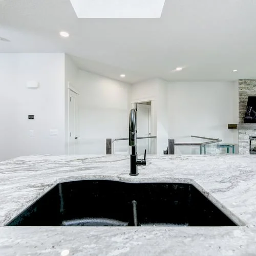 Arbour Lake, Calgary. Marble island with a black sink and the fireplace beyond