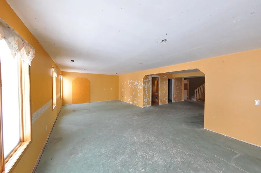 The living space before the work, stripped back to bare floor