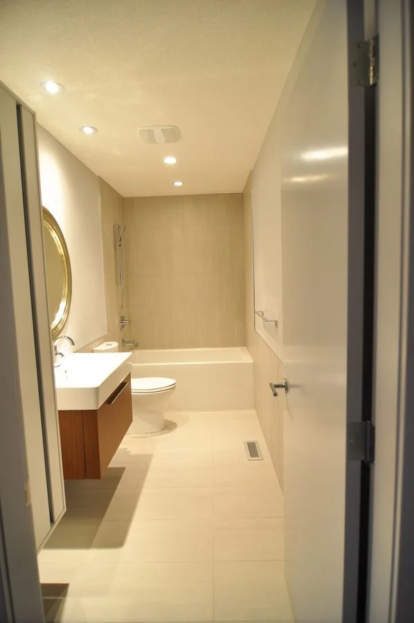 Narrow ensuite with a wall mounted vanity and a full height mirror