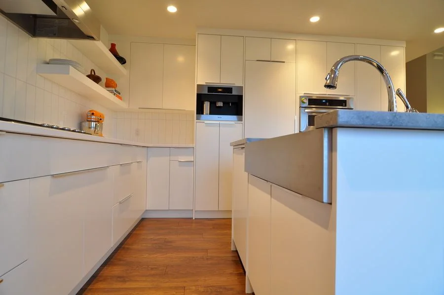 Gloss white kitchen with open shelving and a wide island