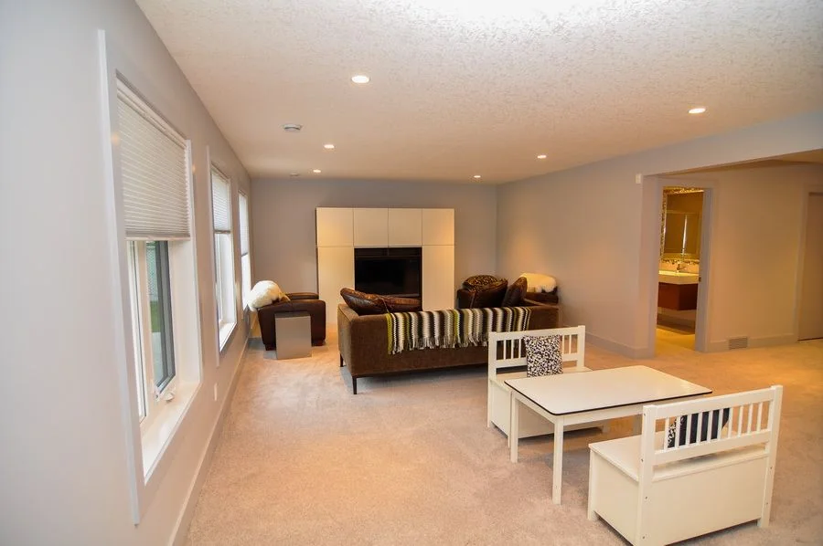 Living room with a corner fireplace and pale carpet