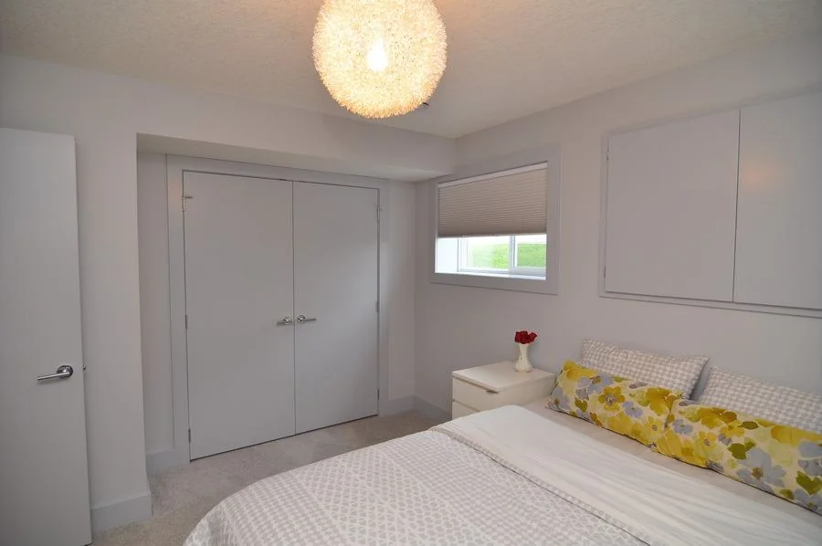 Bedroom with built in wardrobes and a woven pendant light