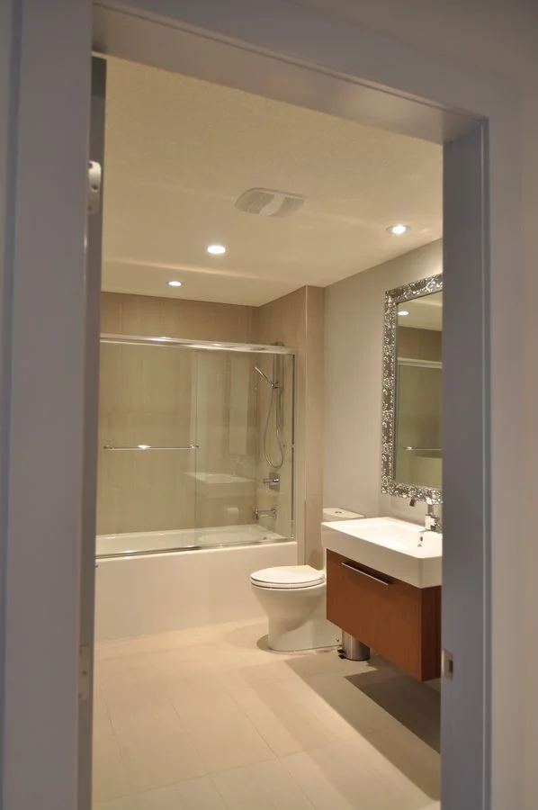 Bathroom with a tub shower and a floating vanity under an ornate mirror