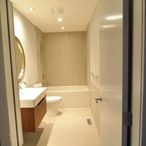Chestermere, Alberta. Narrow ensuite with a wall mounted vanity and a full height mirror