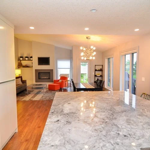 Chestermere, Alberta. Kitchen island in polished stone looking through to the living area
