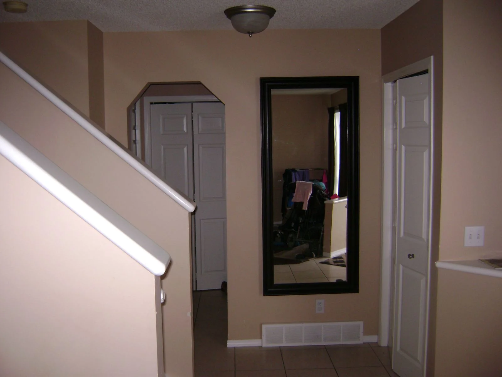Hallway with a tall mirror before renovation