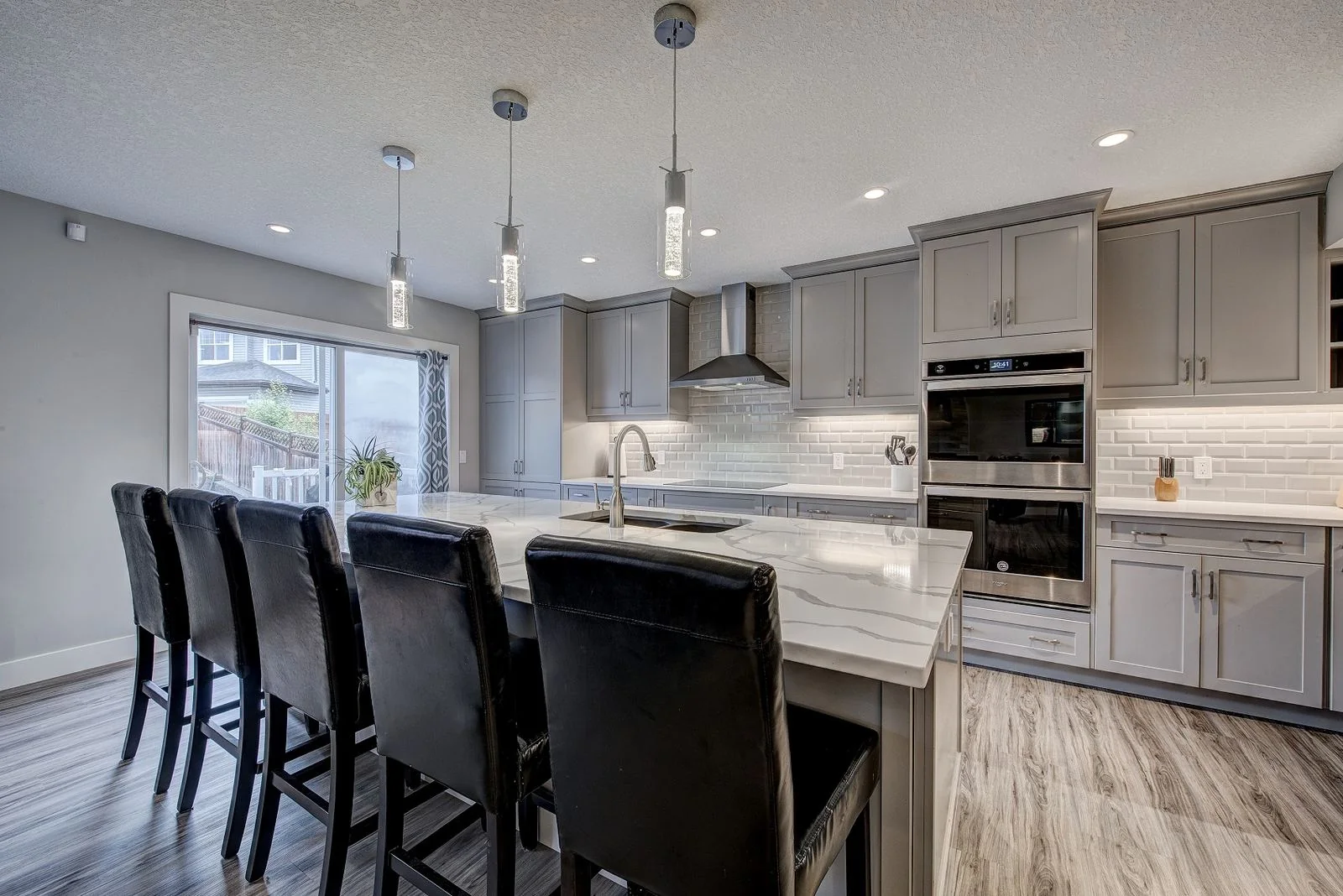 Kitchen with wall ovens and island seating