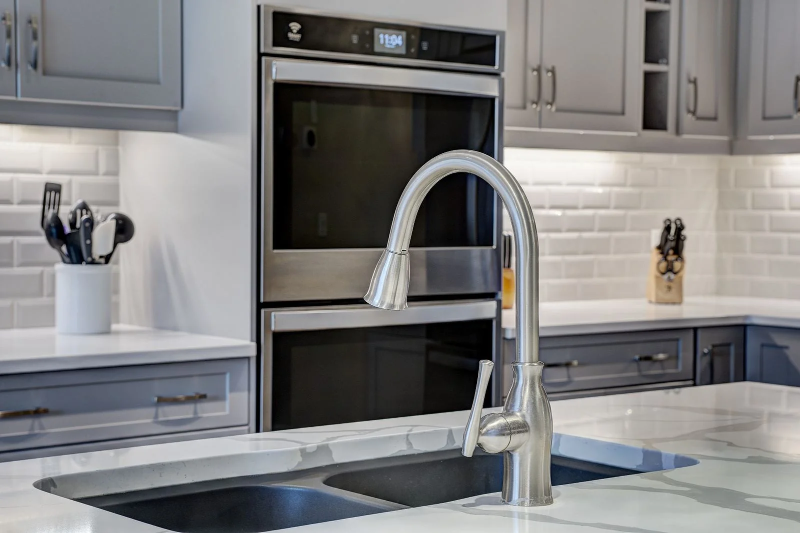 Kitchen sink with double wall ovens beyond