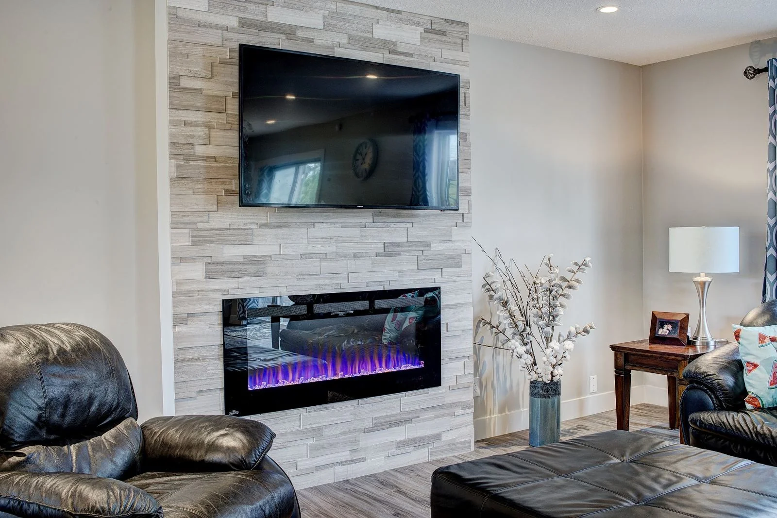 Living room with a linear fireplace and stone surround