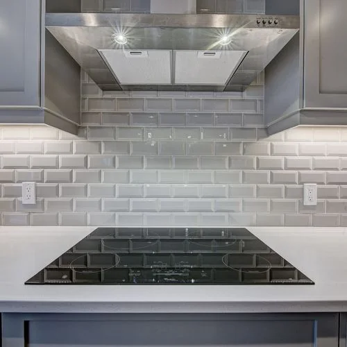 Citadel, Calgary. Cooktop with a stainless hood and tiled backsplash