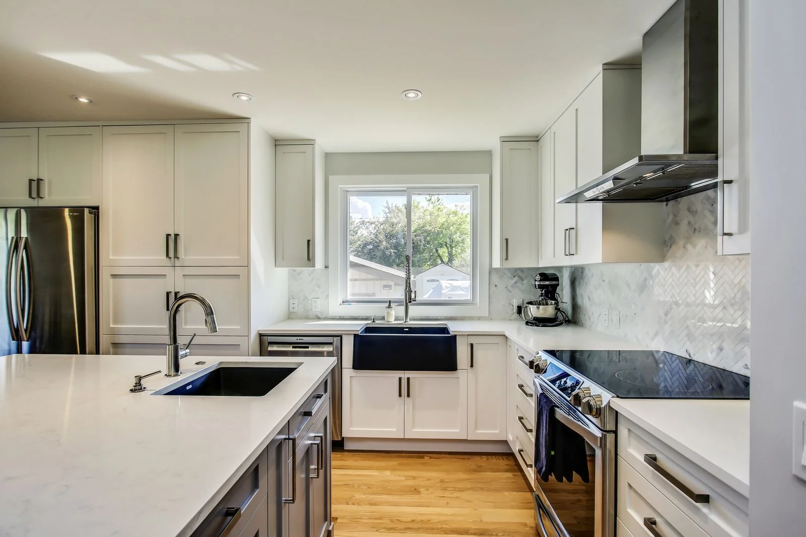 Renovated kitchen with an apron sink and stone backsplash
