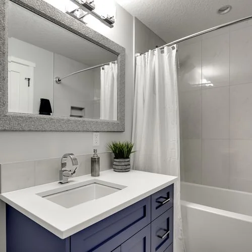 Douglas Dale, Calgary. Bathroom vanity in navy with a tiled tub surround
