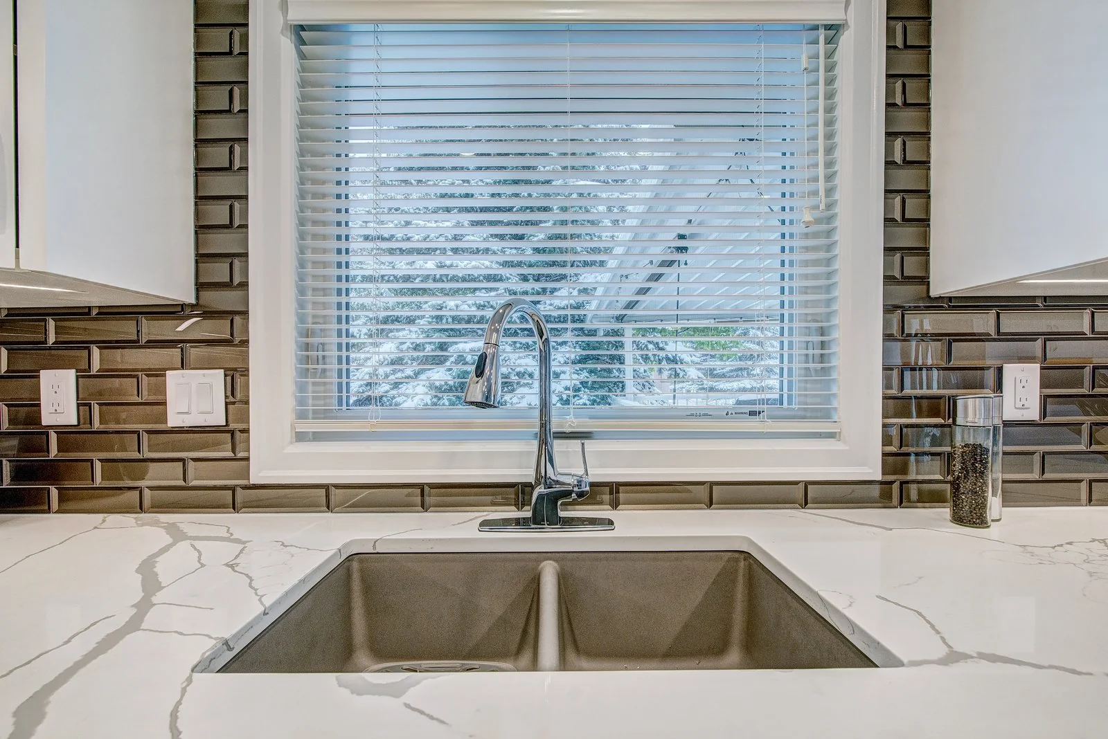 Undermount double sink under the kitchen window with quartz counters