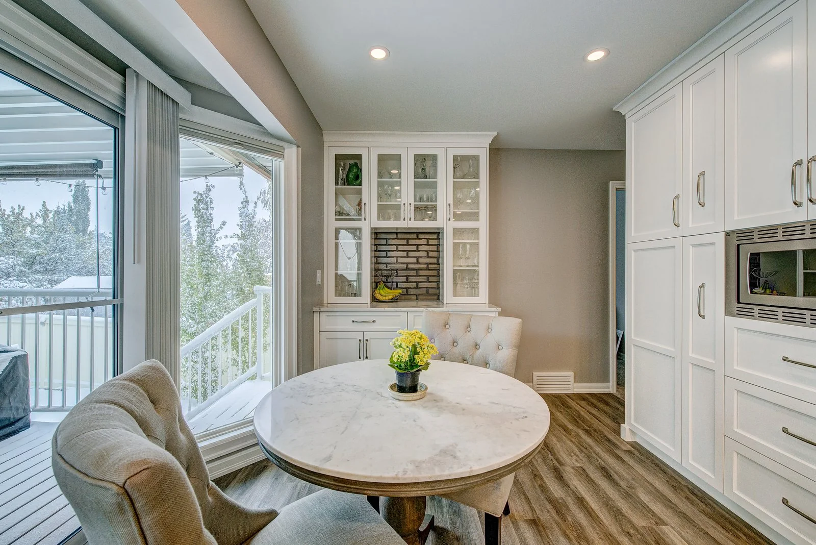 Dining nook with a glass front hutch and doors out to the deck