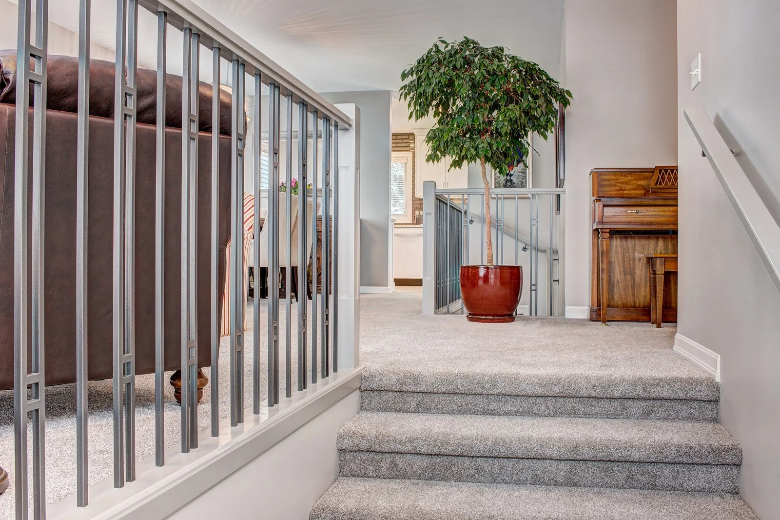Carpeted stair up to the landing with the new metal railing