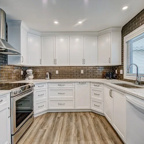 Maxwell, Calgary. Kitchen in white shaker cabinetry with a bronze glass tile backsplash