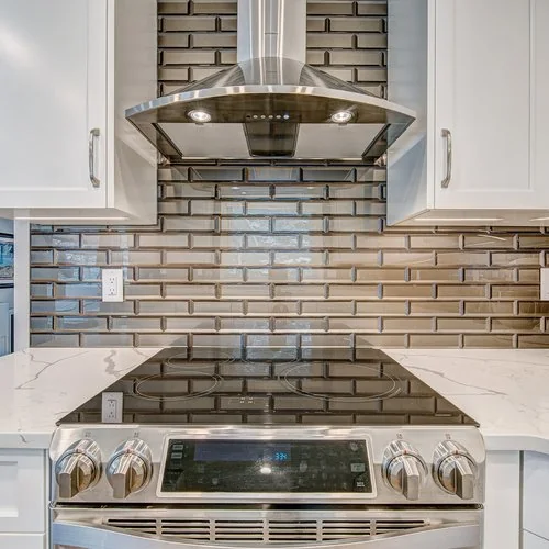 Maxwell, Calgary. Slide in range under a stainless chimney hood