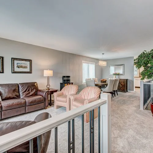 Maxwell, Calgary. Living room with leather seating and striped occasional chairs