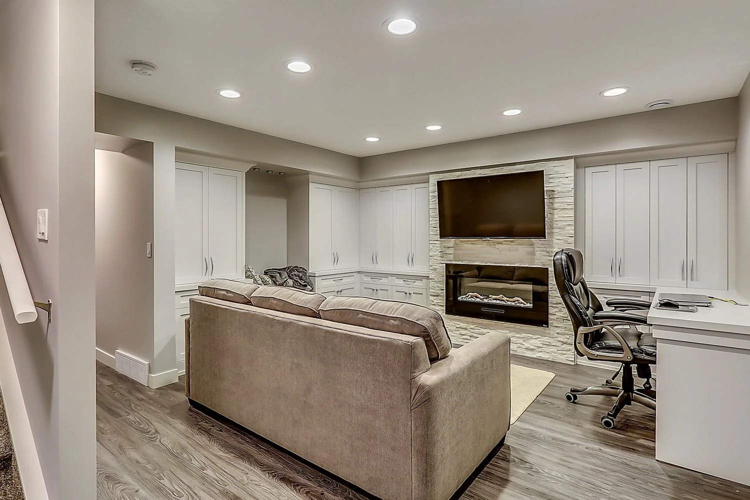 Developed basement with built in cabinetry and a linear fireplace