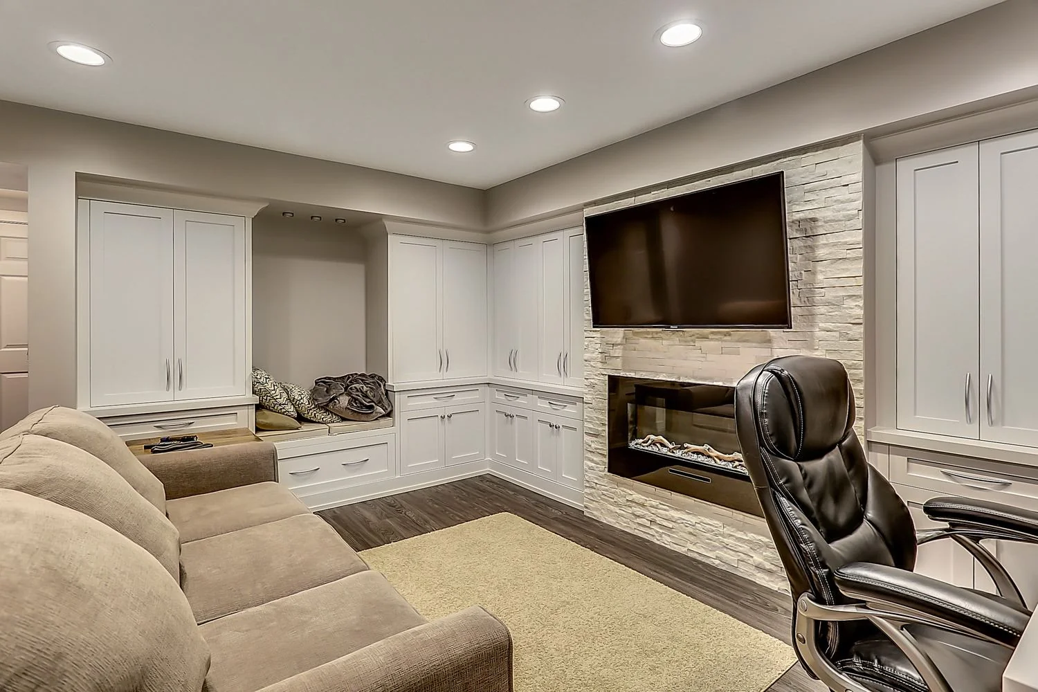 Ranchlands, Calgary. Basement family room with a fireplace and a work area