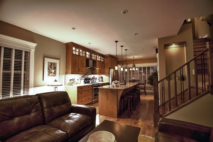 Living room opening to the kitchen and the stair with an iron railing