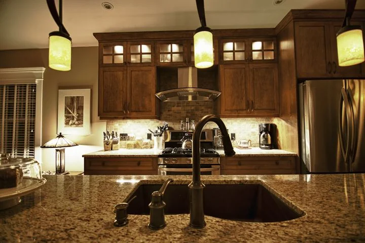 Renfrew, Calgary. Kitchen in dark stained wood with granite counters and glass fronted uppers