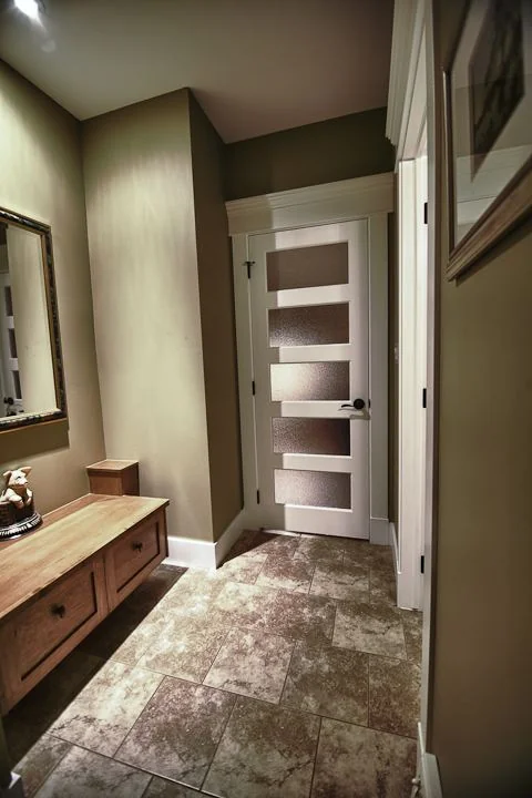 Hallway in tile with a built in linen cupboard and a bench
