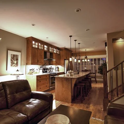 Renfrew, Calgary. Living room opening to the kitchen and the stair with an iron railing