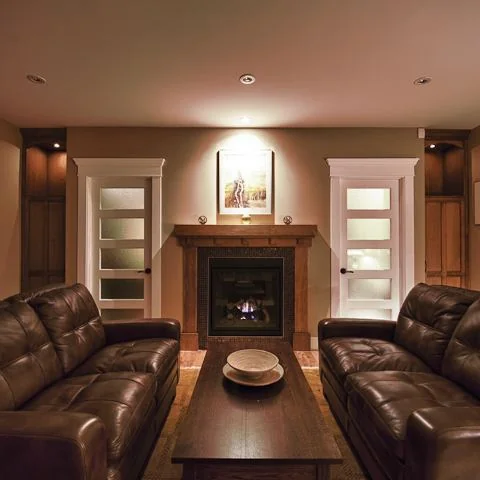 Renfrew, Calgary. Living room with leather seating facing a fireplace and frosted glass doors