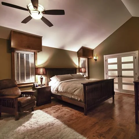 Renfrew, Calgary. Bedroom under a vaulted ceiling with a ceiling fan and hardwood floor