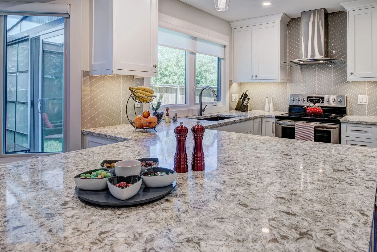 Kitchen island in granite with a stainless range hood