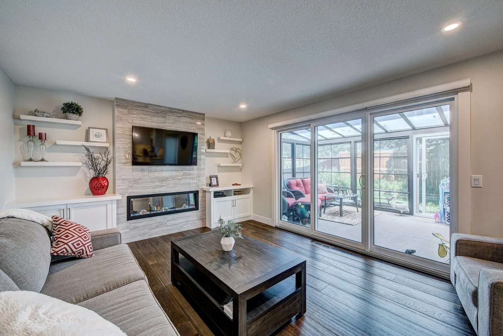 Living room with a linear fireplace and sliding doors