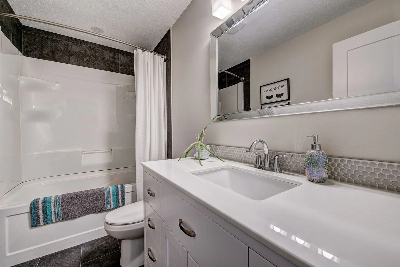 Bathroom vanity with a tub and tiled surround