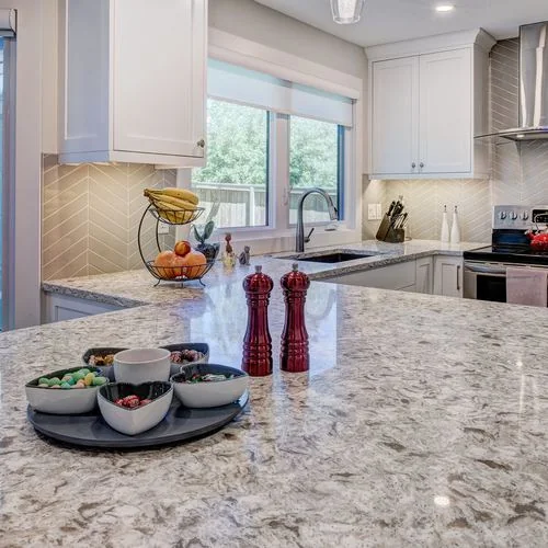 Woodglen, Calgary. Kitchen island in granite with a stainless range hood