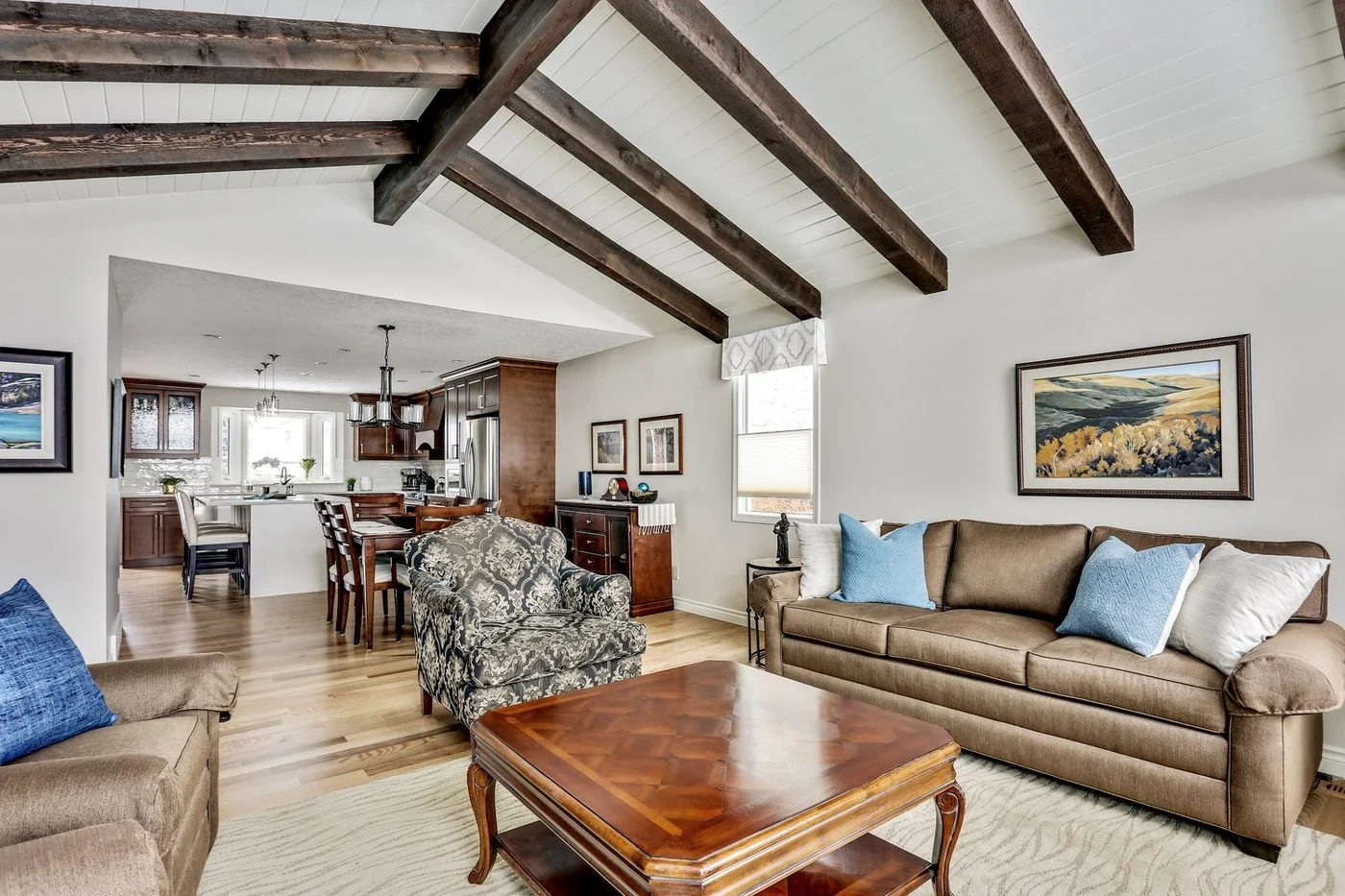 Open living area with exposed beams looking through to the kitchen