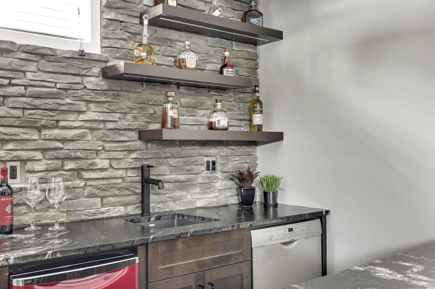Developed basement bar with floating shelves and under counter fridge