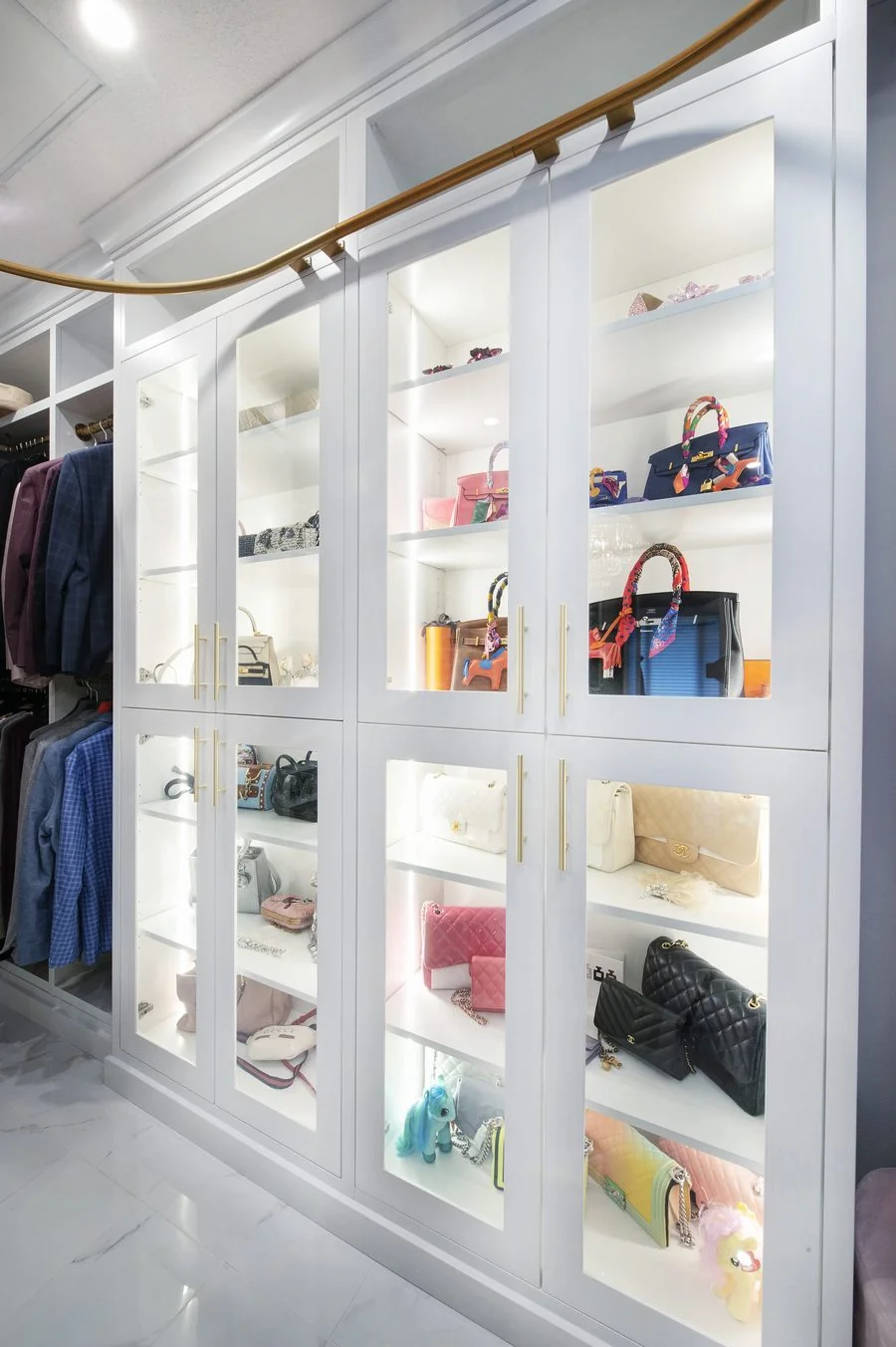 Glass fronted wardrobe cabinetry with interior lighting